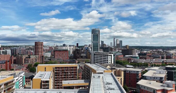 Aerial footage of the Leeds city centre featuring the Bridgewater Place apartment and modern office buildings historic warehouses and the city skyline beneath a bright summer sky with scattered clouds