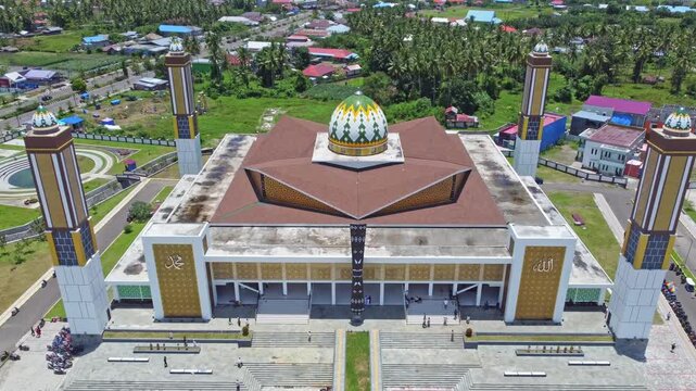 An aerial shot of a magnificent mosque Masjid Raya Shaful Khairaat Sofifi Tidore with mountains and the sea. Ideal for projects on religion, travel, and culture