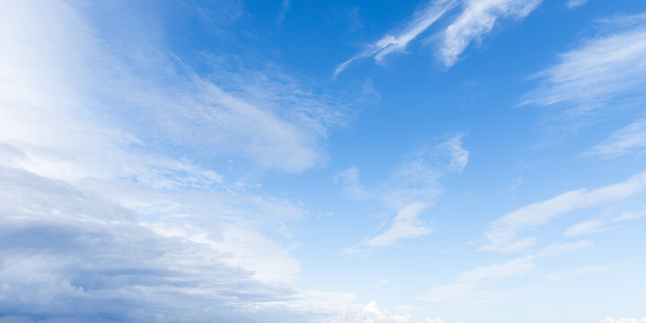 Vast blue sky filled with soft cirrus and cumulus clouds above a distant horizon, creating a calm, airy landscape ideal for backgrounds, travel, weather, and peaceful nature themes