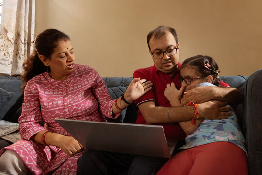 Father comforting daughter while mother discusses in the living room