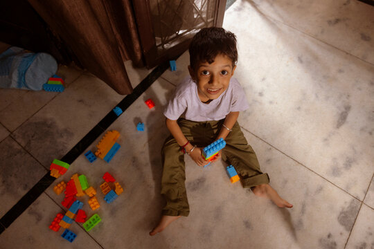 kid looking at camera while playing with toys