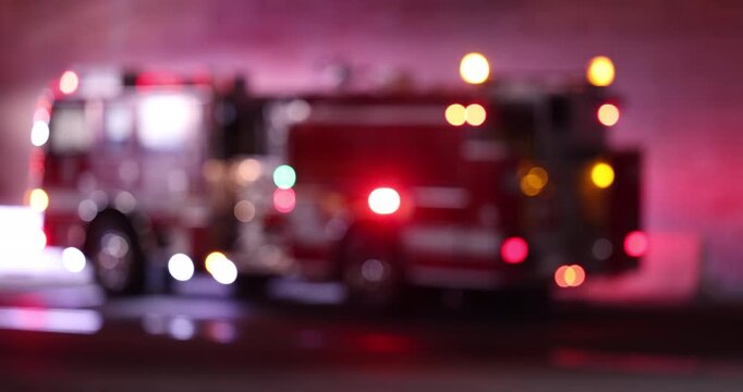 Abstracted de-focused bokeh view of fire engine emergency assets arriving on scene at night.