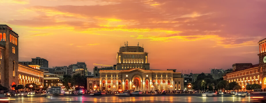 Yerevan. Armenia - June 17, 2026: Scenic twilight view of Republic Square featuring illuminated majestic architecture of History Museum, beautiful orange sunset sky and urban life