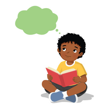 Little African boy reading book thinking day dreaming sitting on floor

