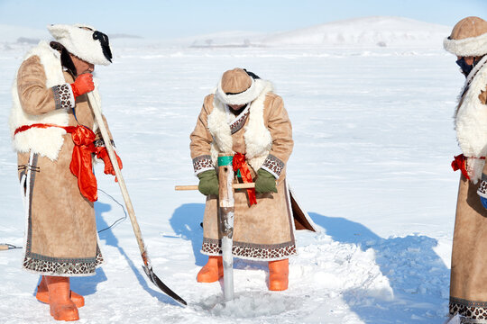 People ice-fishing on the frozen lake during the cold winter.