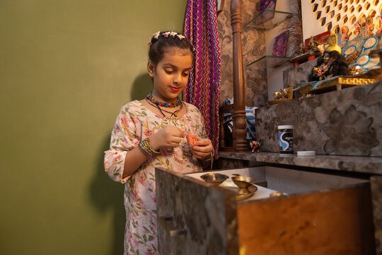 Young girl lighting a lamp for a religious ceremony