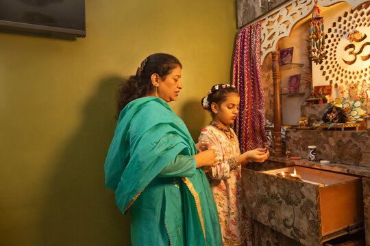 Mother and daughter performing a prayer ritual together