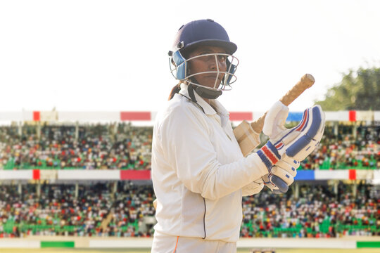 Cricketer ready to bat in a lively stadium