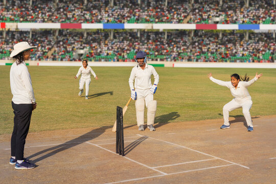 Female cricketers appealing for a wicket on the field