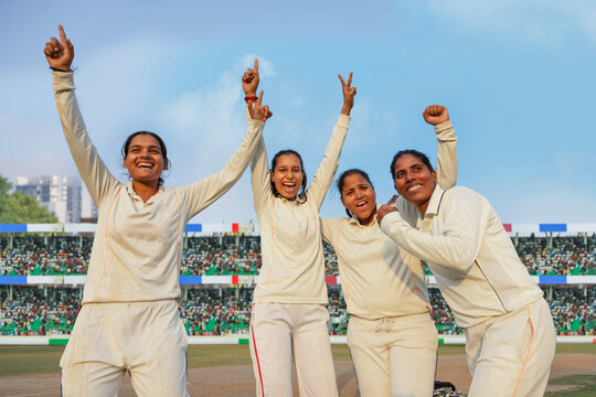 Female cricket team celebrating a victory on the field