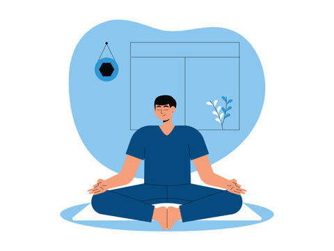 A man meditating cross-legged on a white mat with his feet tucked together, set in front of a large window and a minimalist wall hanging.