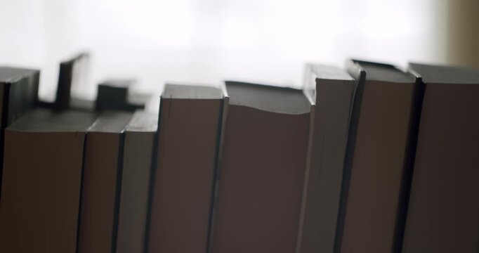 Old books with no titles standing in a row on a wooden shelf in a library or bookstore, symbolizing knowledge, education, learning, literature, and the joy of reading classic novels