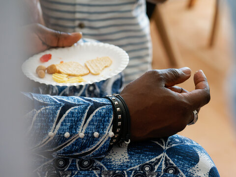 Invit&eacute; tenant une assiette de biscuits ap&eacute;ritifs lors d&rsquo;une r&eacute;ception conviviale ou d&rsquo;un &eacute;v&eacute;nement priv&eacute;