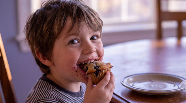 Blueberry month child eating muffin with surprised happy expression for food nutrition baking family lifestyle website promotion design