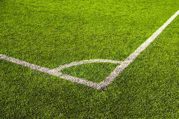 Top view of green artificial grass with white marking lines on soccer field. Football pitch corner kick area with synthetic turf. Athletic sports ground texture background © Gereish