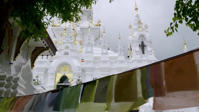 Slow motion slider over Buddhist Flags and temple in Thailand