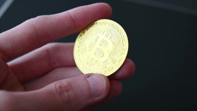 Golden bitcoin coin on dark textured surface shows cryptocurrency logo