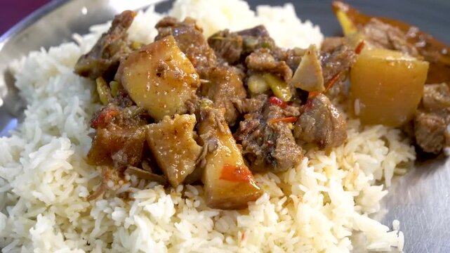 Panning shot of boiled pork served with rice in traditional Northeast Indian Assamese style