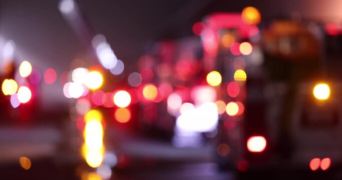 Abstracted de-focused bokeh view of fire engine emergency assets arriving on scene at night.