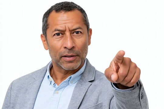 Serious mature man in gray blazer pointing finger directly at camera with intense stern expression on white background. Authoritative middle-aged male with accusatory or you gesture