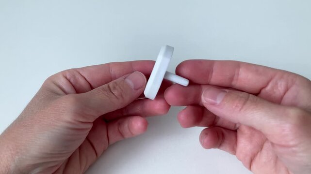 A woman shows kids plug protector, child safety. A reliable helper to prevent any dangerous electrical games