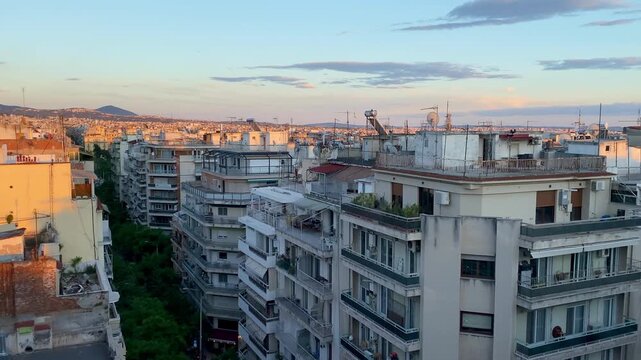 Greece pan across Thessaloniki rooftop cityscape at sunset
