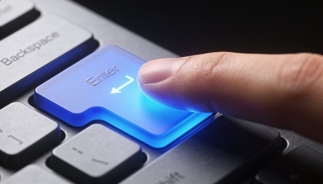 Pressing adult fingertip pressing blue-lit Enter key at desk, showing Backspace, gray keycaps