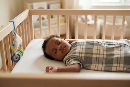 Peaceful sleeping infant resting comfortably inside a crib