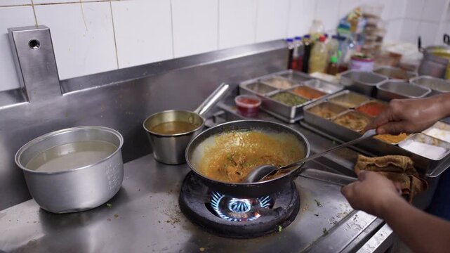 Professional Chef Cooking Indian Chicken Curry in Commercial Kitchen Wok