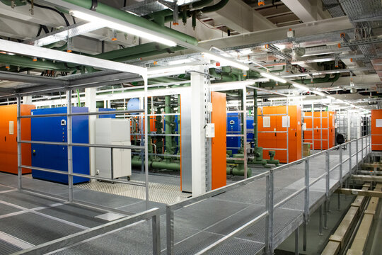 Lugano, Ticino, Switzerland - 18 March 2026: View of the Swiss National Supercomputing Centre, featuring rows of colorful server cabinets, industrial piping, and metal walkways.