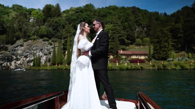 Bride and groom share a tender moment on a boat on Italy's Lake Como