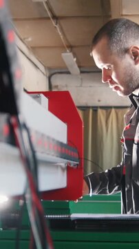 Electrician in overalls is working with energy panel and machinery equipment on plant