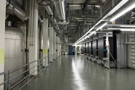 Lugano, Ticino, Switzerland - 18 March 2026: View of the industrial interior at the Swiss National Supercomputing Centre featuring large metal cooling pipes and technical machinery.