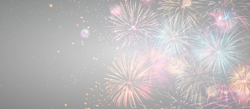 Colorful fireworks display illuminating the night sky with vibrant bursts of light in various shapes and colors against a soft gray background