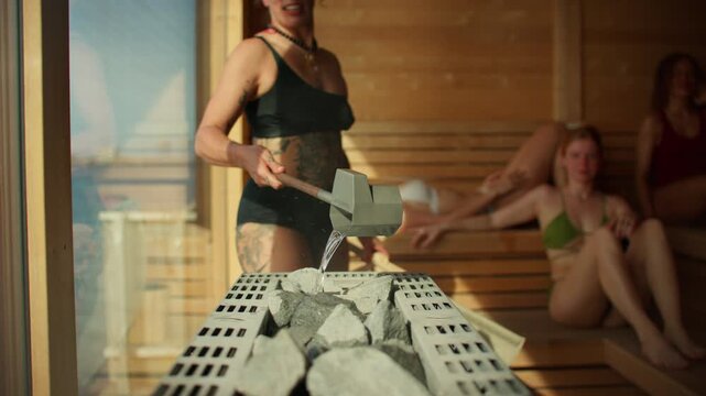 The sauna session shows a woman pouring water during an aufguss ritual