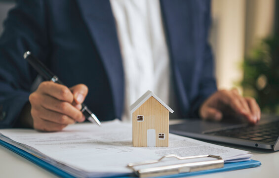 Home insurance and mortgage documentation concept with house model property protection planning real estate financing contract approval and residential investment management