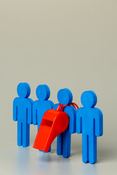 A red whistle hanging on a blue figure among a group on a grey background. A conceptual image representing a corporate whistleblower, reporting misconduct. Copy space for text.