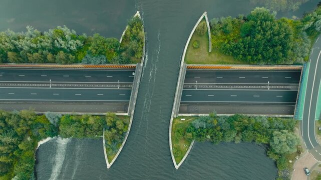 Top-down drone shot of the Harderwijk aqueduct showing cars driving beneath a water bridge. A striking example of Dutch engineering with smooth traffic flow and modern infrastructure.
