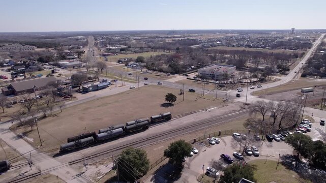 4K drone push-in footage of railroad tracks in downtown Midlothian, Texas, highlighting transportation infrastructure, urban development, and North Texas city scenery.
