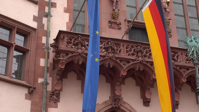Closeup shot of German and European Union flags hanging on a historical building