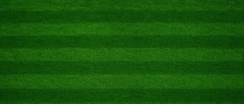 Top view of natural green grass with horizontal mowing stripes, creating a well manicured soccer or rugby field texture and sports stadium background