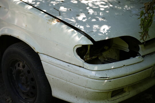 Damaged front end of an old passenger car with missing headlight illustrating accident damage insurance claims and vehicle repair costs