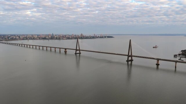 Drone panorama of the San Roque Gonzalez International Bridge spanning the Parana River with Posadas city visible in the background.