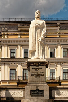 Kyiv, Ukraine - 11 June 2026: View of the white marble monument of Princess Olga standing before a historic yellow building under a cloudy sky.
