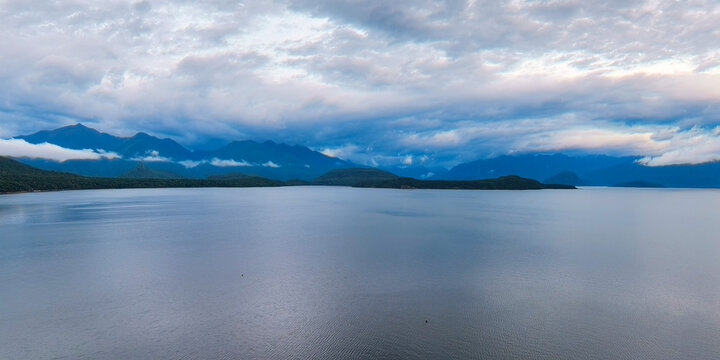 The lake and distant mountain fjords under the cloudy sky, Manapouri, New Zealand