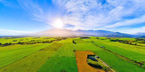 Aerial view of green pastures and distant mountains under the blue sky, New Zealand © zhang