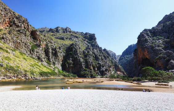 Sa Calobra. Balearic beach in a cove. Majorca beach. Mass tourism. Tourists on a protected beach.