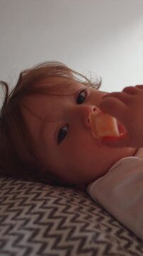 Young child enjoying fresh fruit snack while relaxing in bedroom, highlighting healthy nutrition, childhood wellbeing, comfort and everyday family life