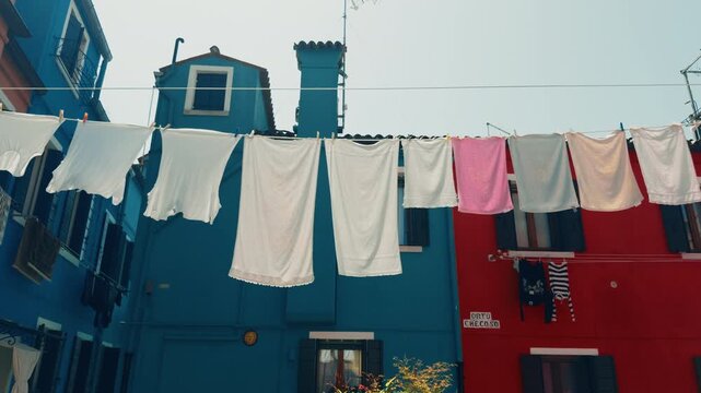 Burano laundry hanging across bright blue facade