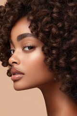 Fototapeta premium Profile of a beautiful woman with dark coily hair. Her radiant skin softly glows. She shows natural elegance and captivating features on a neutral background.